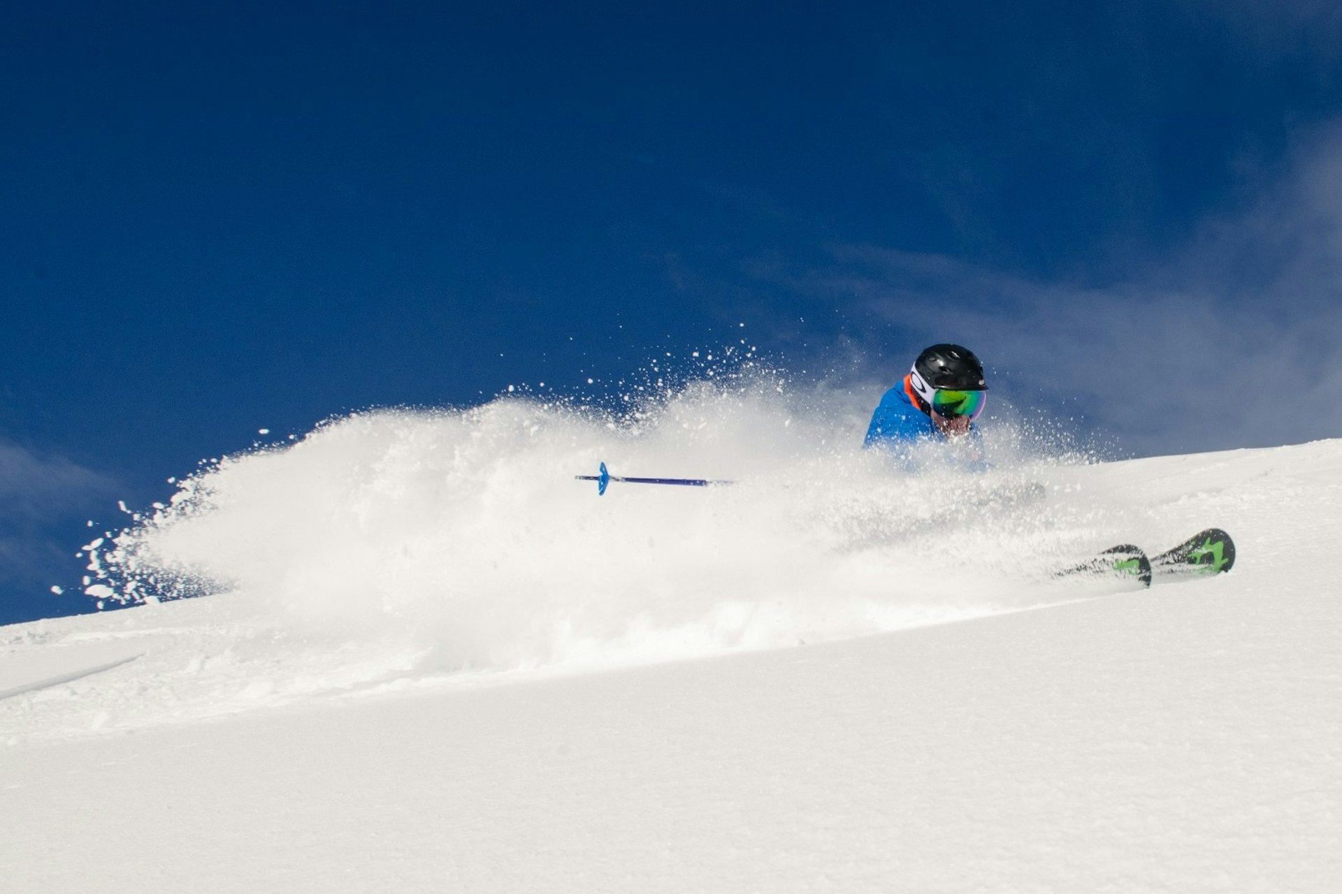 A skier gracefully descends a snow-covered slope, surrounded by a winter landscape.