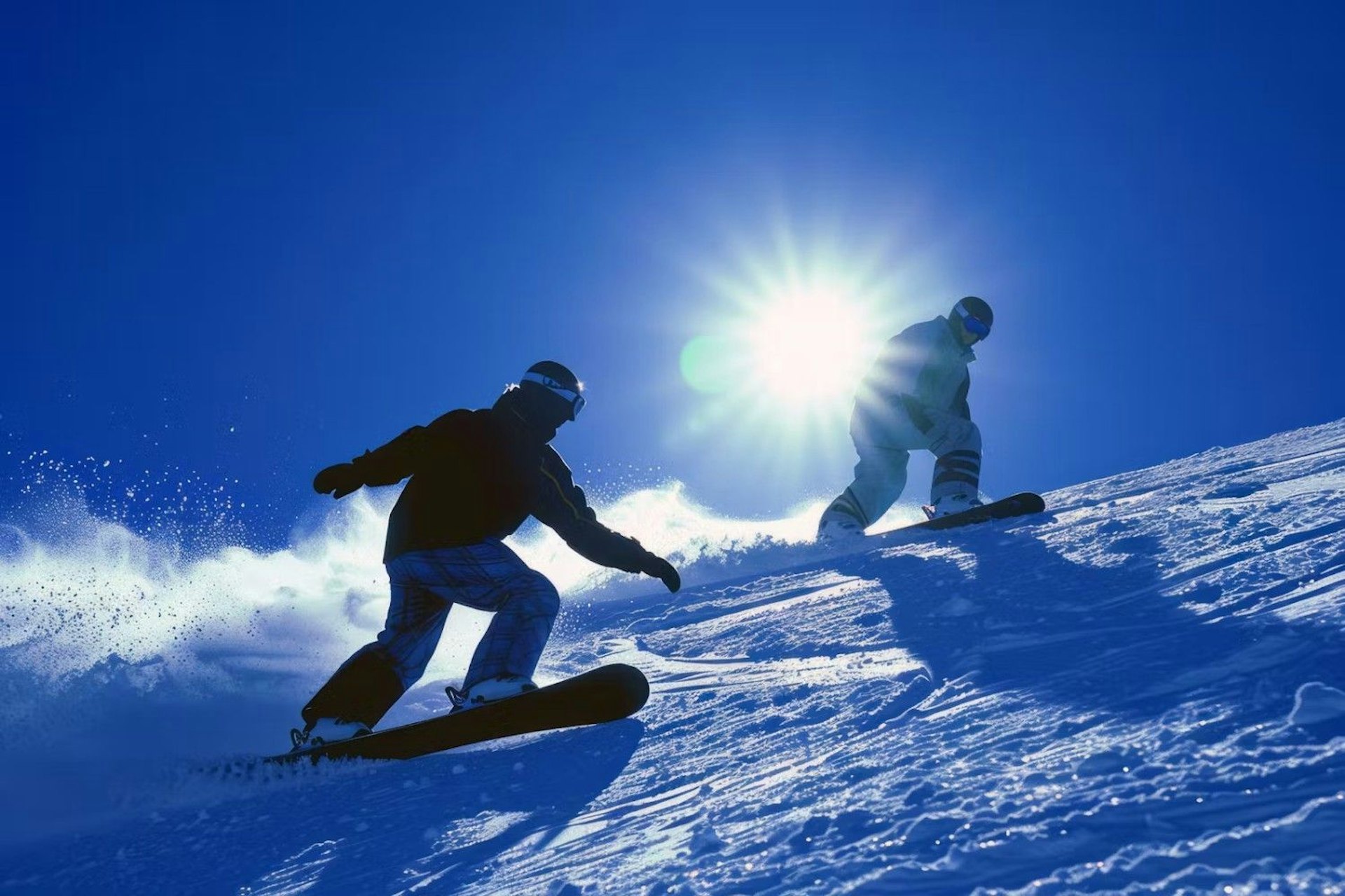 Two snowboarders glide down a snowy slope, showcasing their skills against a backdrop of winter scenery.