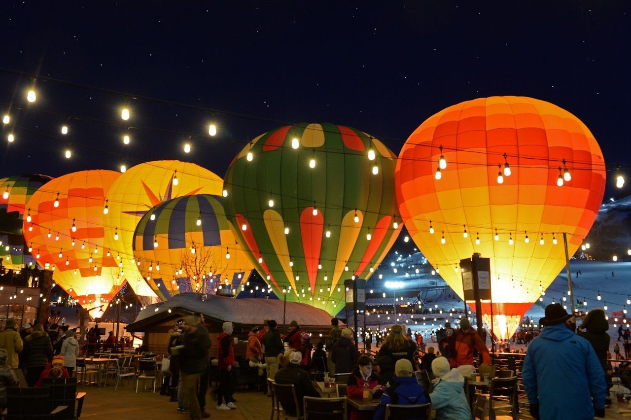 Colorful hot air balloons illuminated against a night sky, creating a vibrant and enchanting display of light.