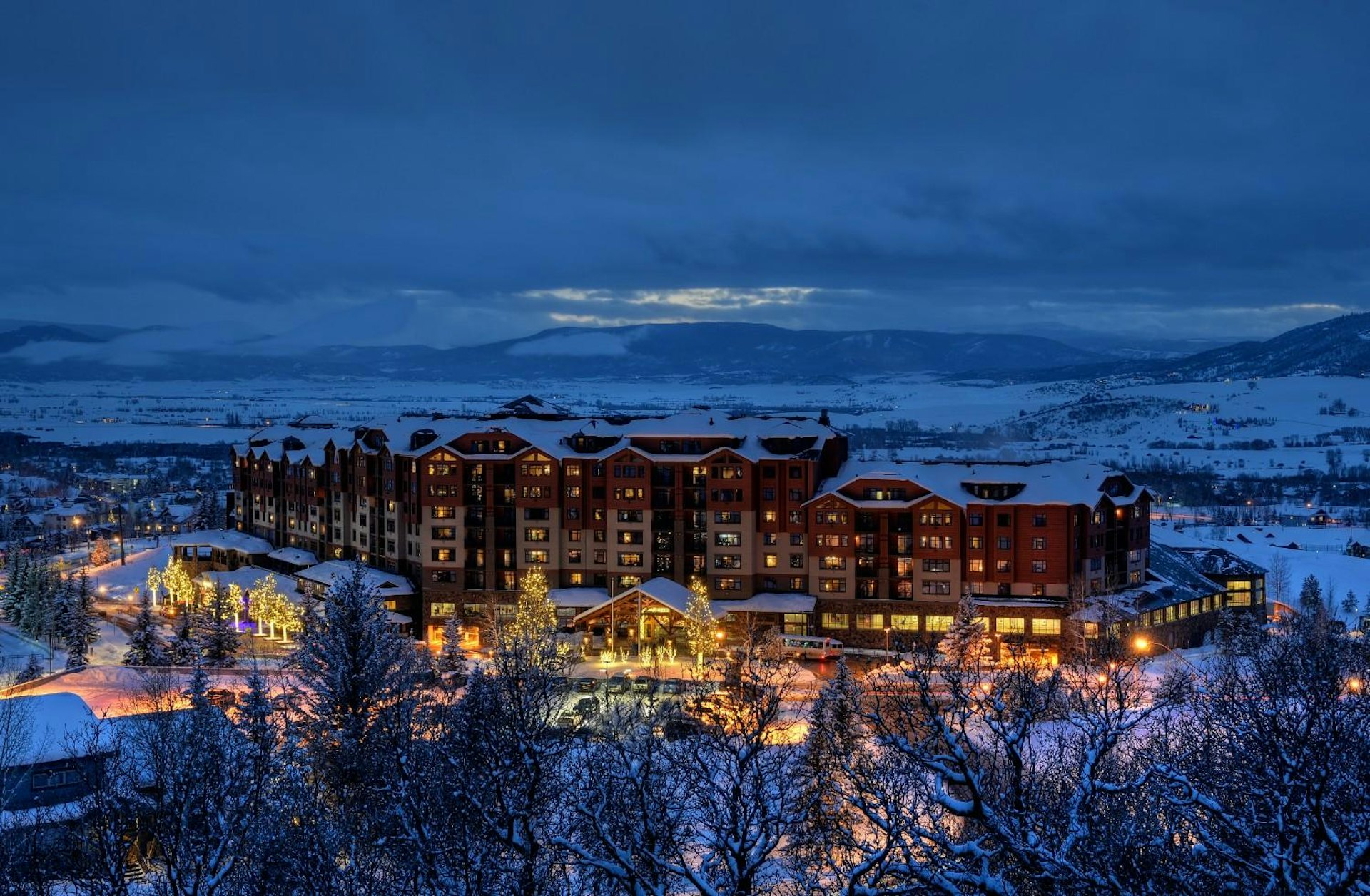 The resort illuminated at night, surrounded by a blanket of snow, creating a magical winter atmosphere.