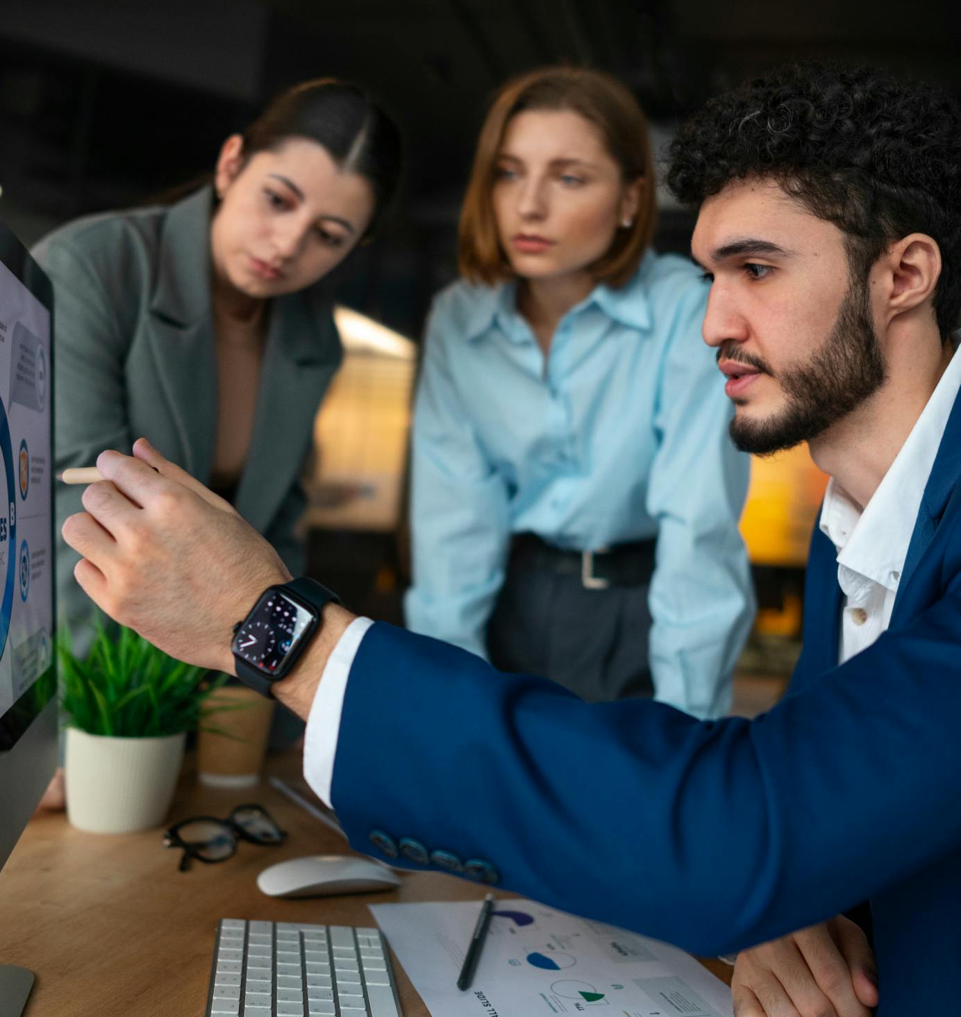 people in an office gathered around a screen