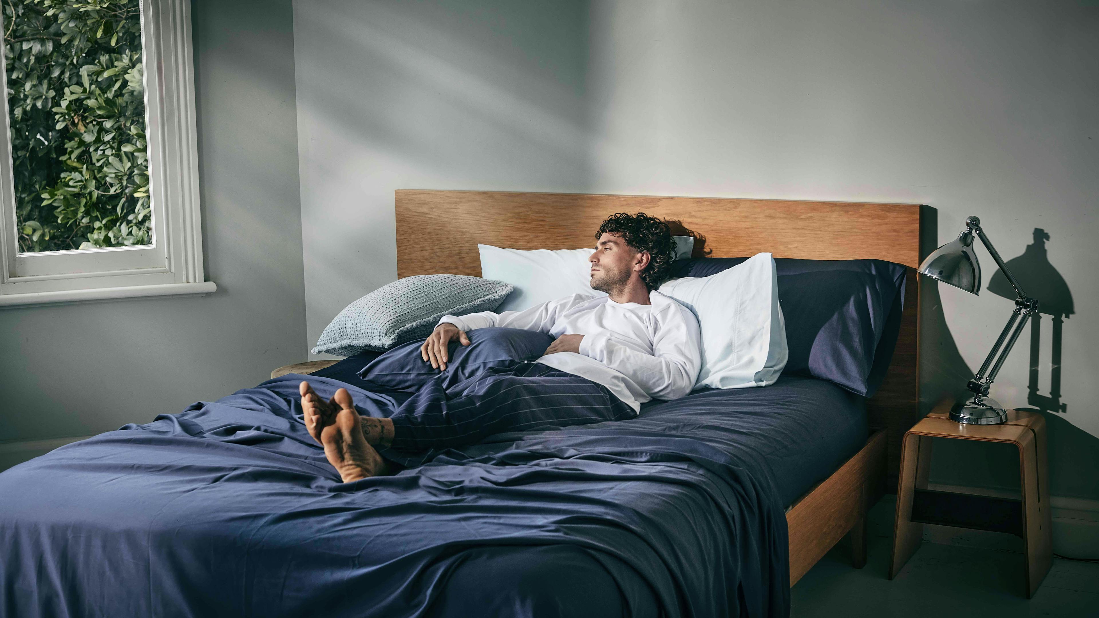 Man in blue bed sheets