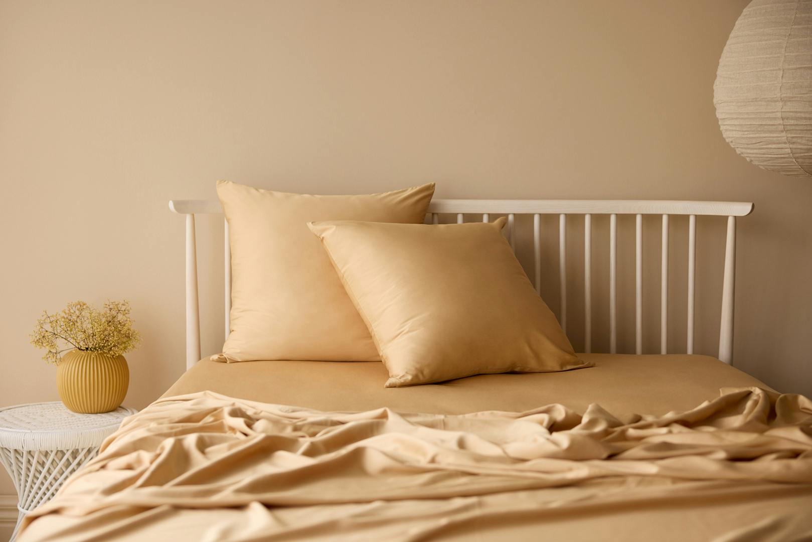 A warm neutral bedroom layered in rich caramel-toned Butter Cookie bedding, capturing the cosy, cocooning elegance of the 2026 interior colour trend with soft textures and timeless appeal.