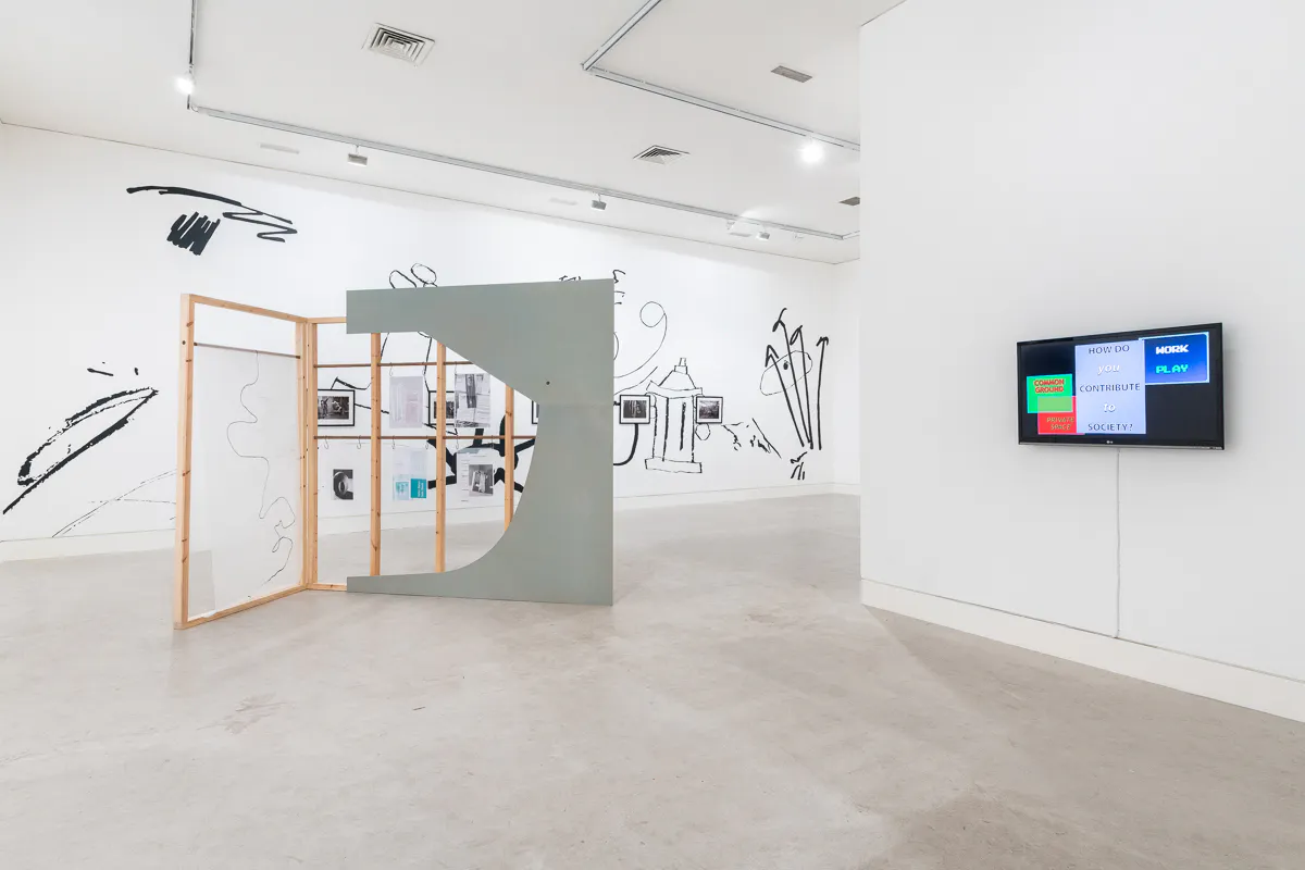 An installation of large sculptural works are situated in a bright gallery space. On the back wall is a large scale black and white painting encompassing over sized doodles.