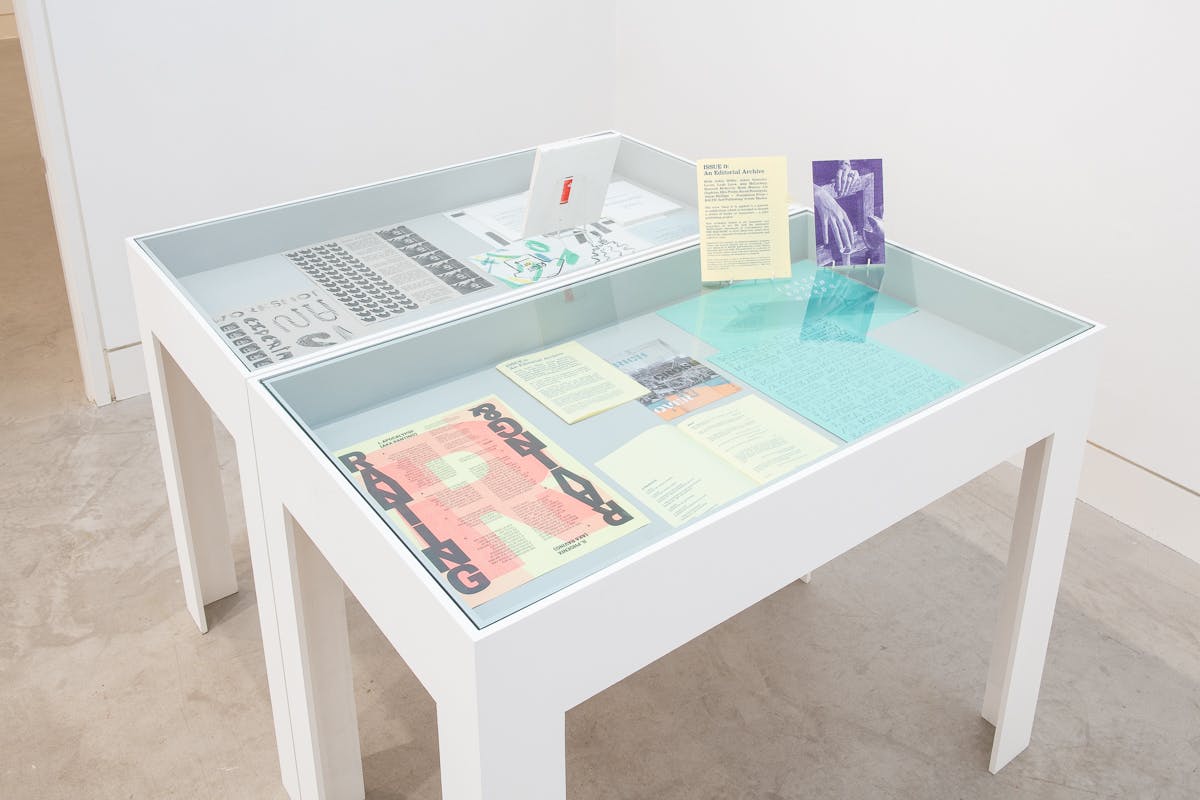 A vitrine contains lots of brightly coloured archival material taken from workshops.