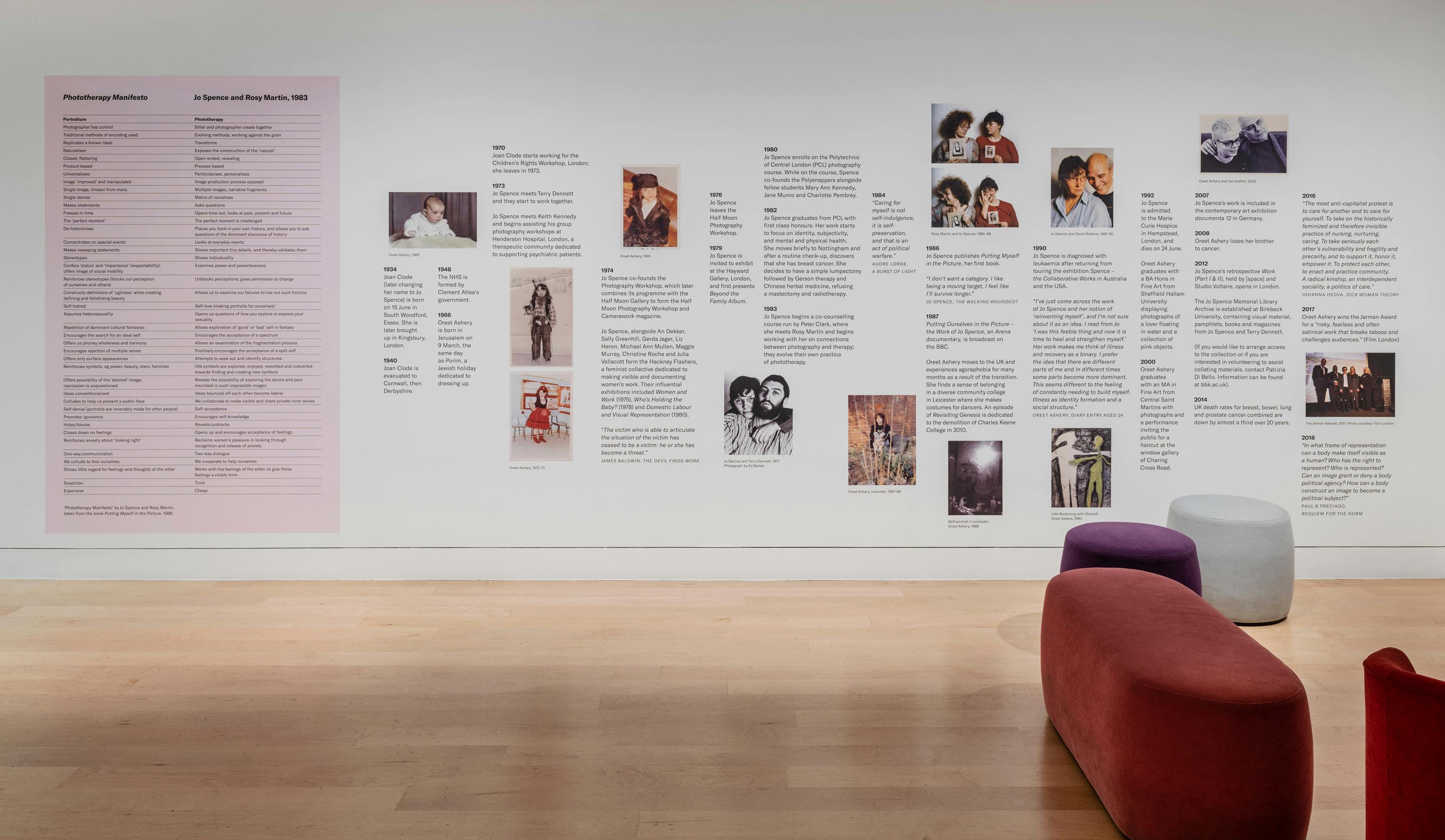 A wall includes a time line of Oreet Ashery and Jo Spence's life including lots of family photographs and biographical information.