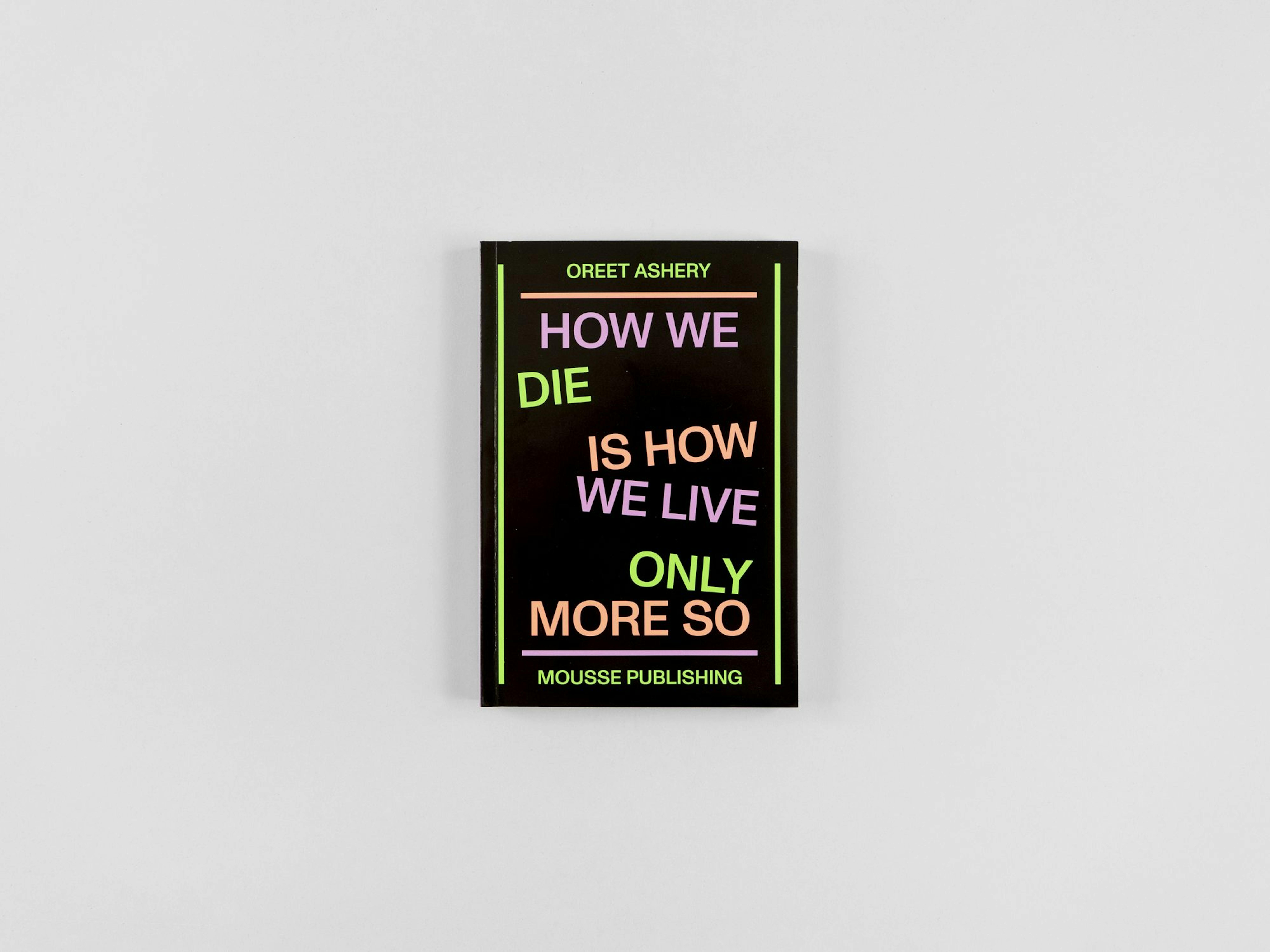 A picture of a book in black with bright typography that says "who we die is how we live only more so."  