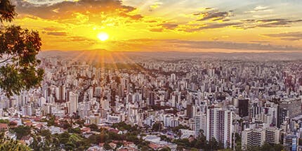 Imagem panorâmica dos prédios da cidade de Belo Horizonte ao pôr do sol.