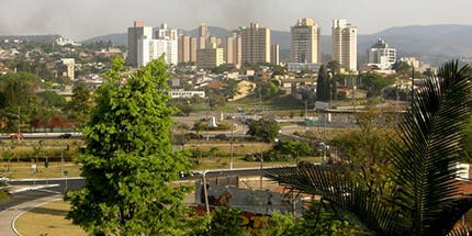 Imagem da cidade de Jundiaí, em São Paulo. A foto mostra as ruas da cidade ao amanhecer, com uma paisagem de prédios e montanhas ao fundo.