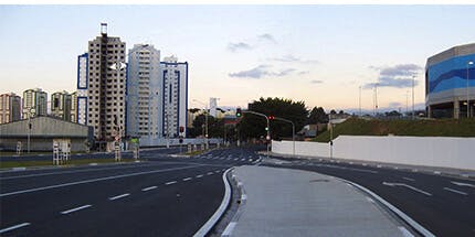 Imagem das ruas da cidade de Osasco, em São Paulo. A foto mostra o amanhecer da cidade, com foco nas ruas asfaltadas, e paisagem de prédios ao fundo.