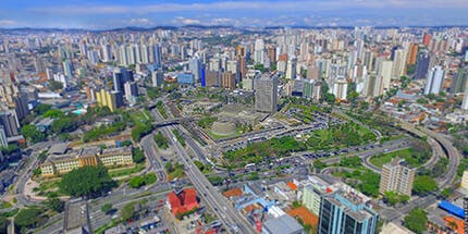Imagem panorâmica de Santo André, em São Paulo. A foto mostra a paisagem de prédios em dia ensolarado. 