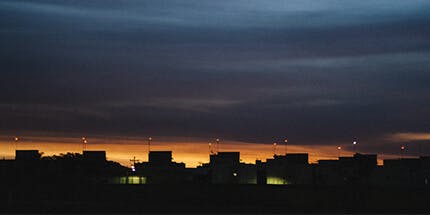 Imagem da cidade de Franca, em São Paulo, ao entardecer. A foto mostra o céu alaranjado contra a paisagem de prédios.