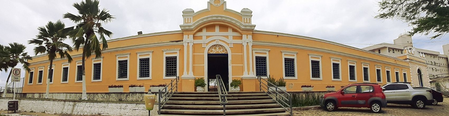 Panorama do edificio do Centro de Turismo de Natal. A construção é antiga com a fachada amarela. Ao lado direito há carros estacionados.