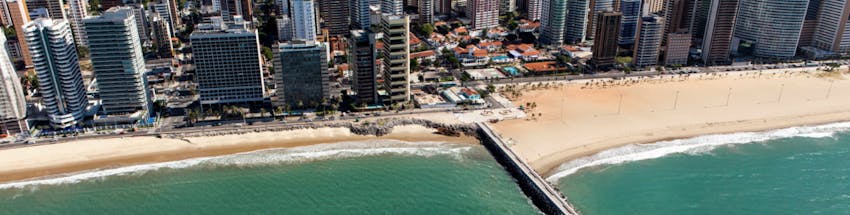 Praia em Fortaleza com vista para os prédios à beira-mar.