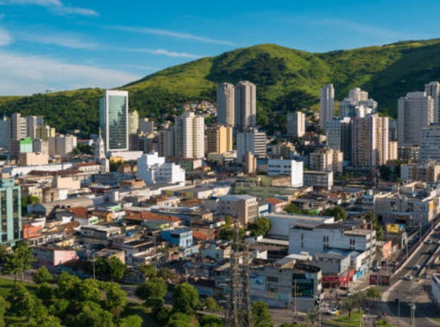 Vista panorâmica dos prédios e grandes montanhas que cercam a cidade de Duque de Caxias, no Rio de Janeiro.
