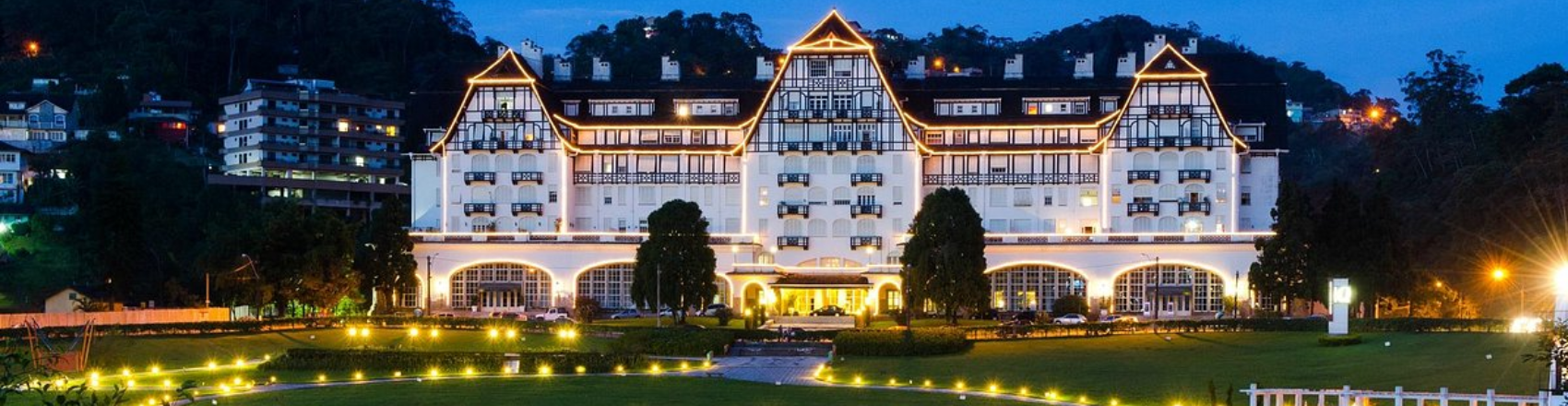 Na imagem, vemos o Palácio Quitandinha, que foi construído a partir de 1941 em Petrópolis e possui uma arquitetura típica europeia, com paredes brancas e telhado triangular. 