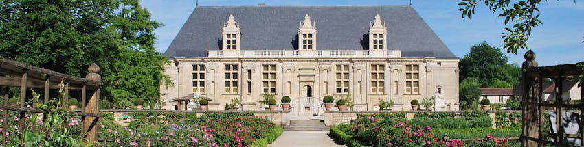 Hotel histórico em Joinville. É conhecido como Grand Jardin. Em primeiro plano o jardim com flores rosas cobrem as laterais da foto. Em destaque, no meio da foto, está o hotel.