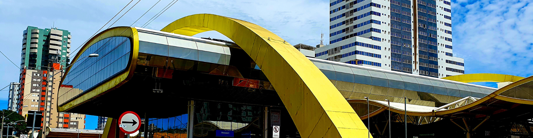 Terminal de ônibus de Maringá com uma estrutura de ferro em amarelo passando por cima do terminal.