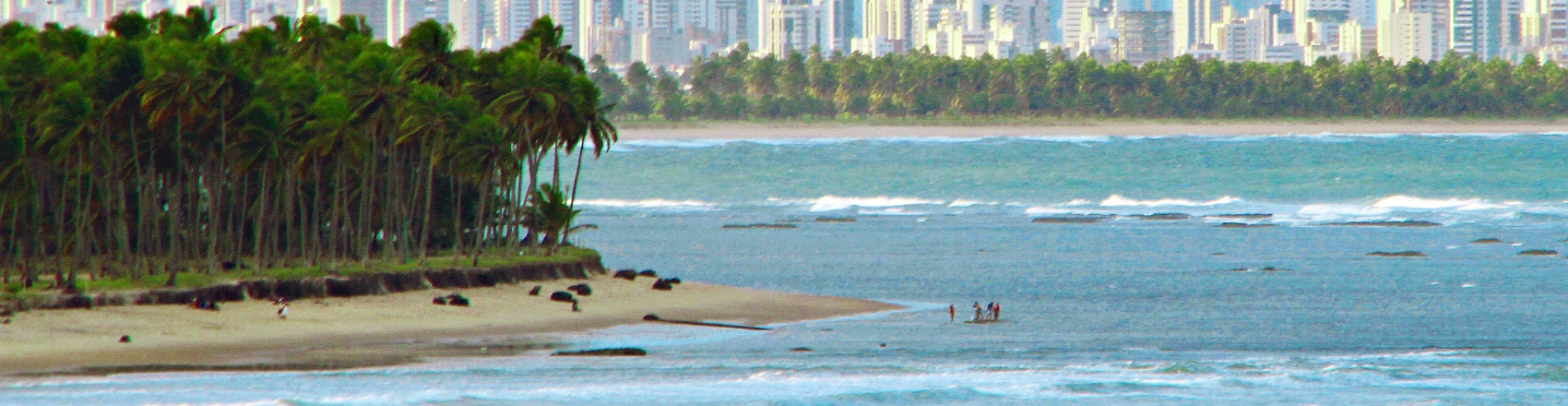 Praia de Fortaleza com banhistas no mar.