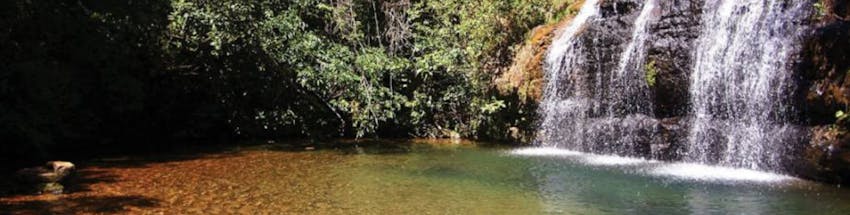 Cachoeira da Cascatinha em Caldas Novas. Há muita vegetação na foto e água caindo da pedra.