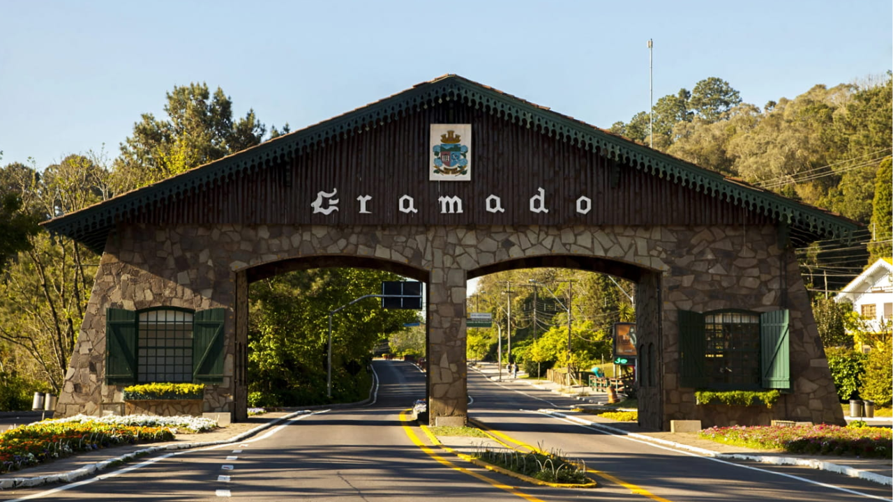 Entrada de Gramado, no Rio Grande do Sul, com jardim de cor verde e a entrada em formato de arco, feito de pedras.