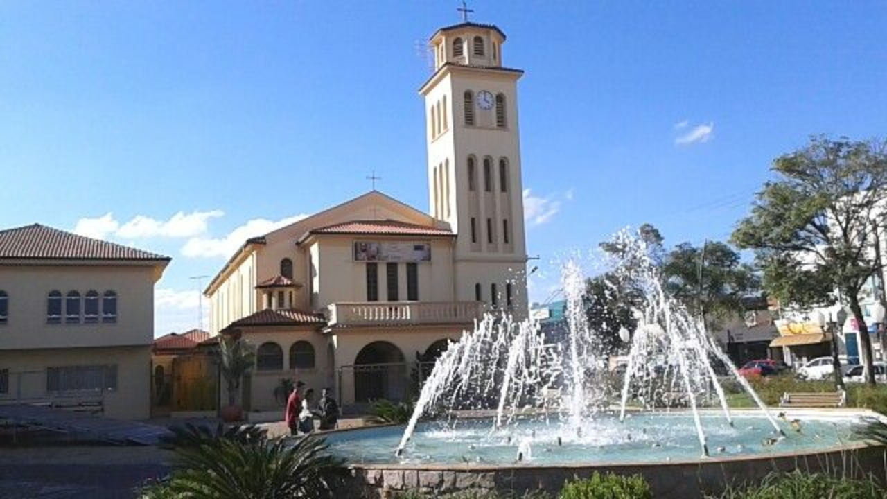 Ponto turístico da cidade de Boituva, com um edifício nude de arquitetura colonial, uma fonte de água na frente e um jardim com grama e plantas verdes.