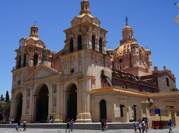 Catedral de Córdoba, Argentina, com sua arquitetura barroca e torres imponentes iluminadas sob um céu azul claro, localizada na Plaza San Martín, ponto turístico histórico e religioso
