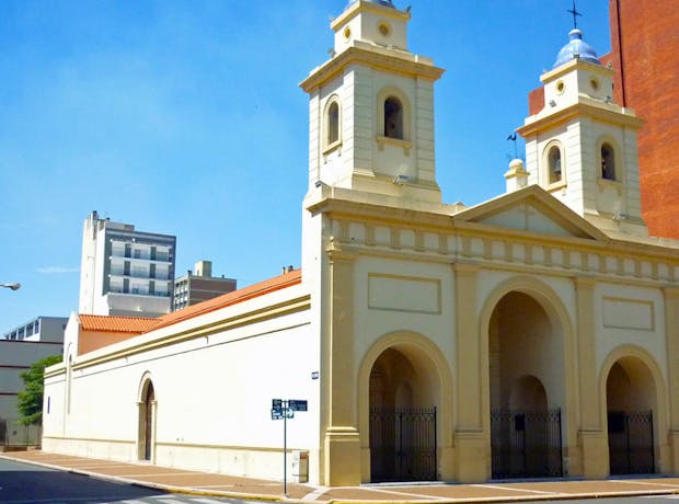 Igreja Catedral Metropolitana de Santa Fe, Argentina, com fachada neoclássica branca, duas torres com sinos e cúpula ao fundo, localizada no centro histórico da cidade em dia ensolarado