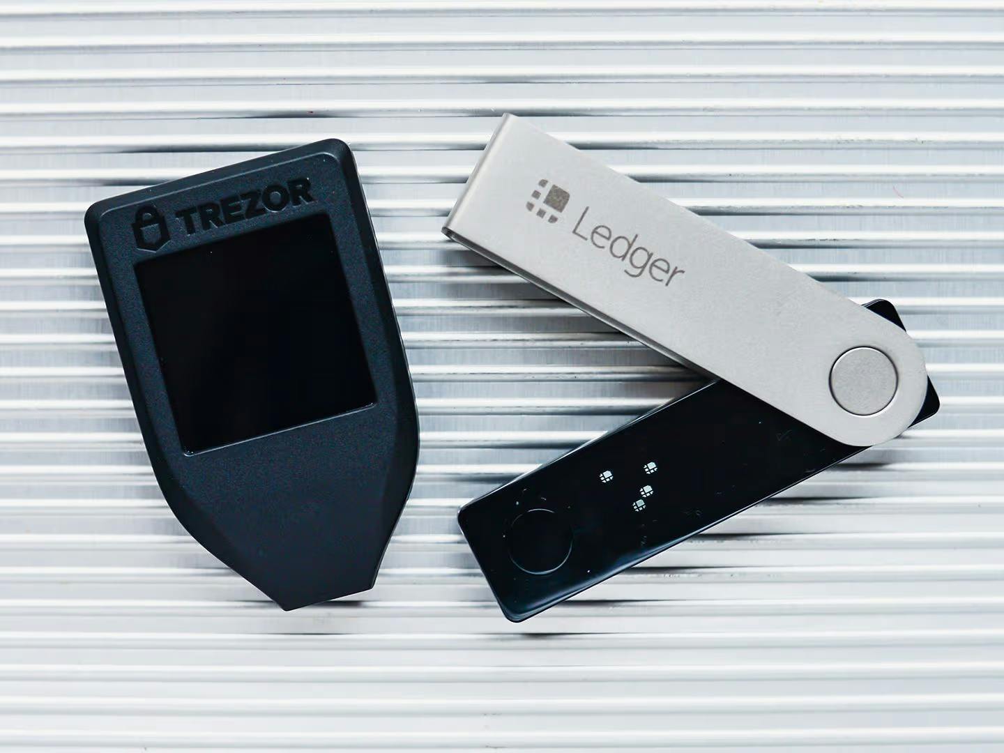 Trezor and Ledger wallets lying together