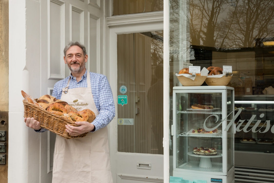 Company Bakery business owner holding bread outside the shop