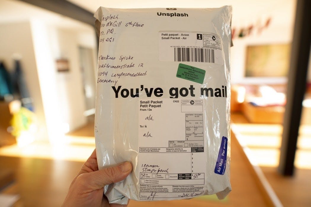 The image focuses on an image that is being held up with &quot;You've got mail&quot; written across the front.
