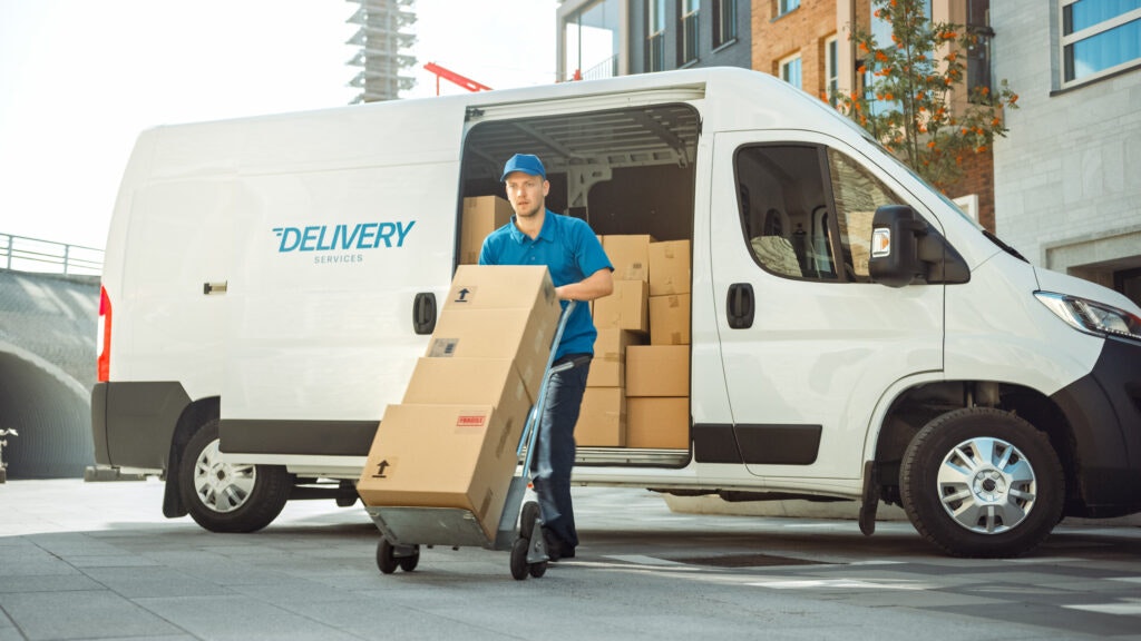 How to Make Money as a Courier: Courier taking a stack of packages from a white truck