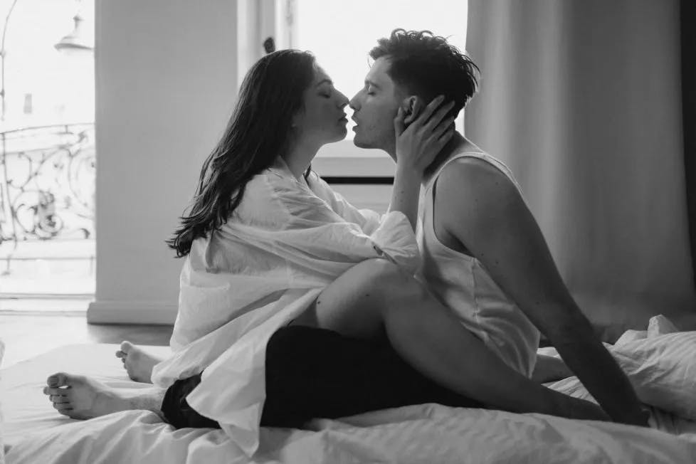 couple kissing in bed