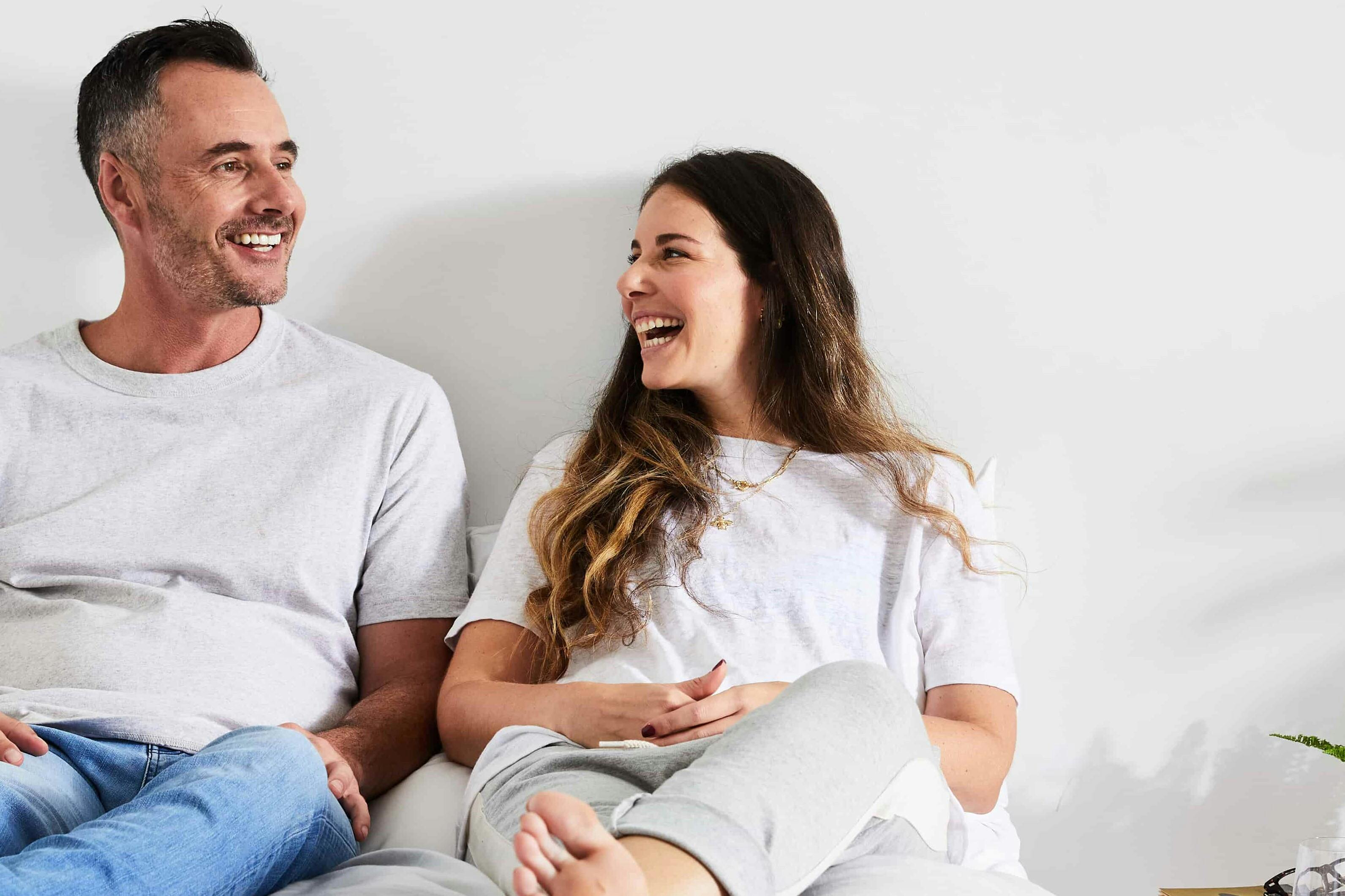 Couple happily sitting on bed
