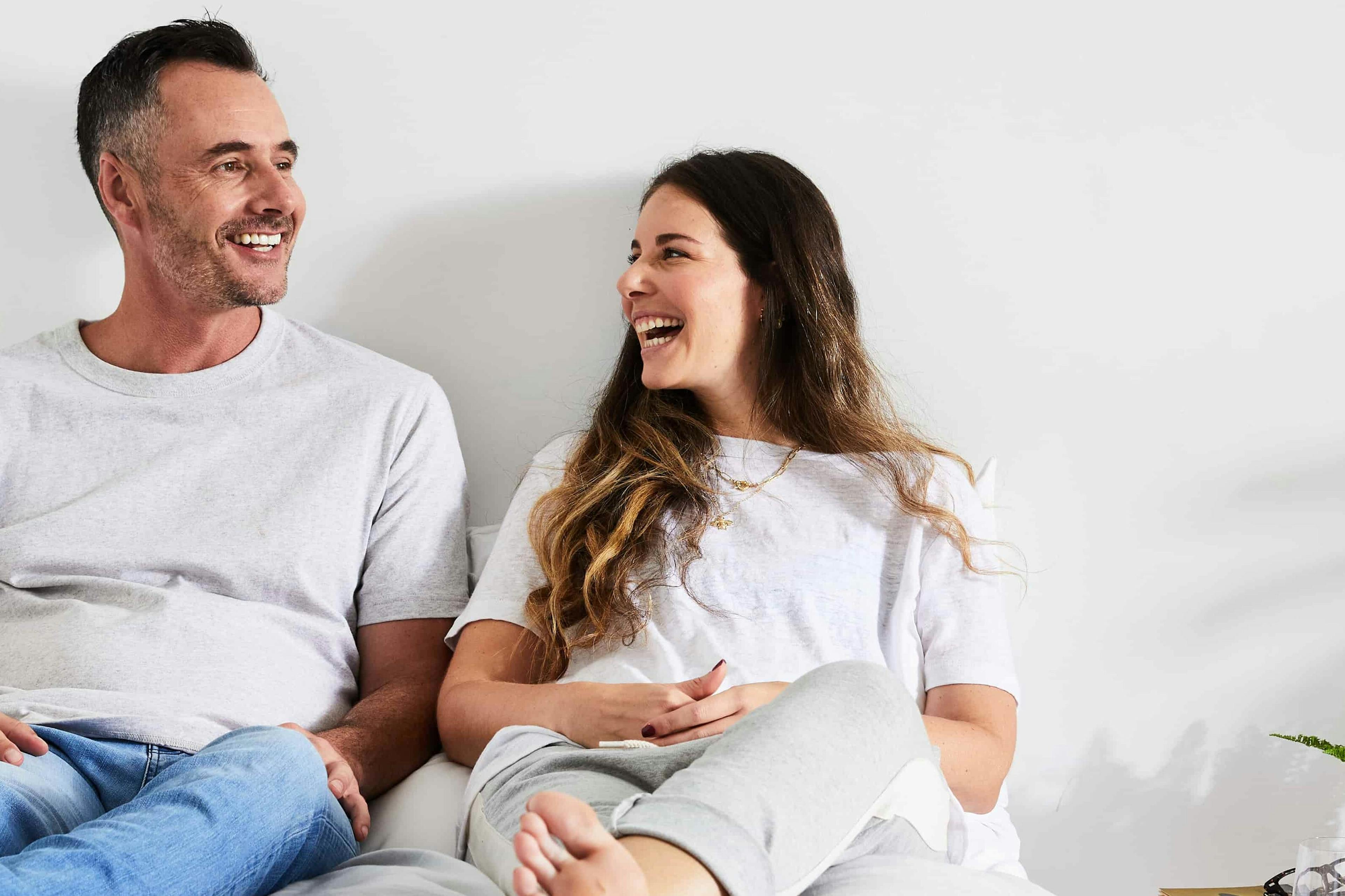 Couple happily sitting on bed