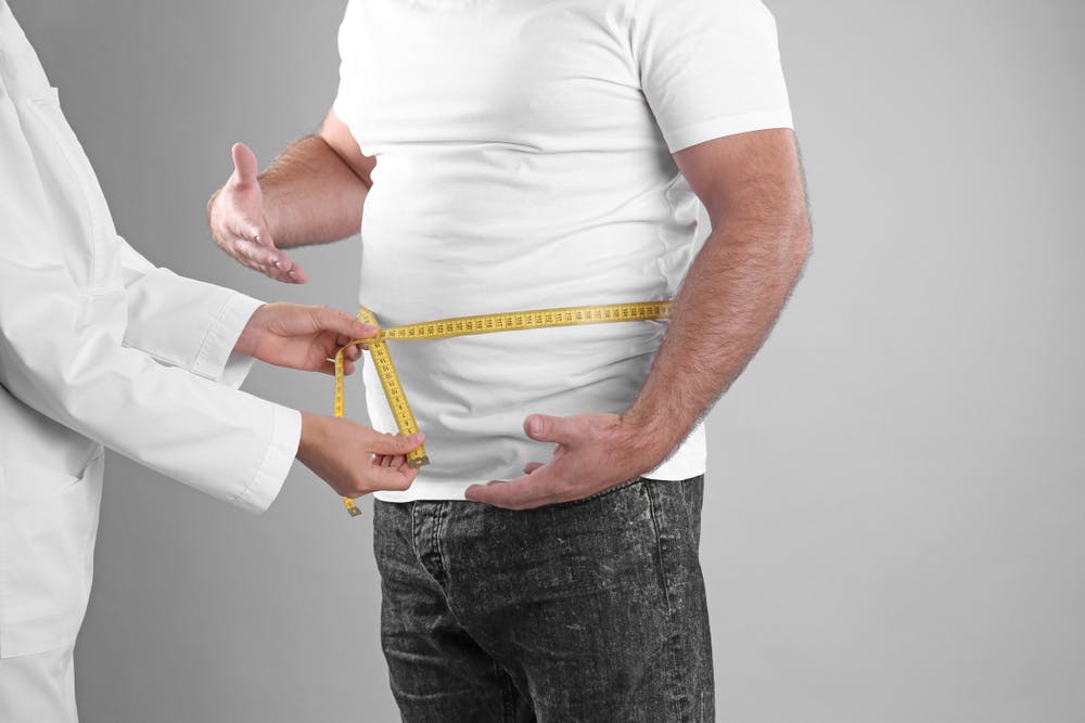 Doctor taking belly measurement of a man