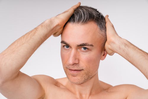 A man checking his hair growth treatment results