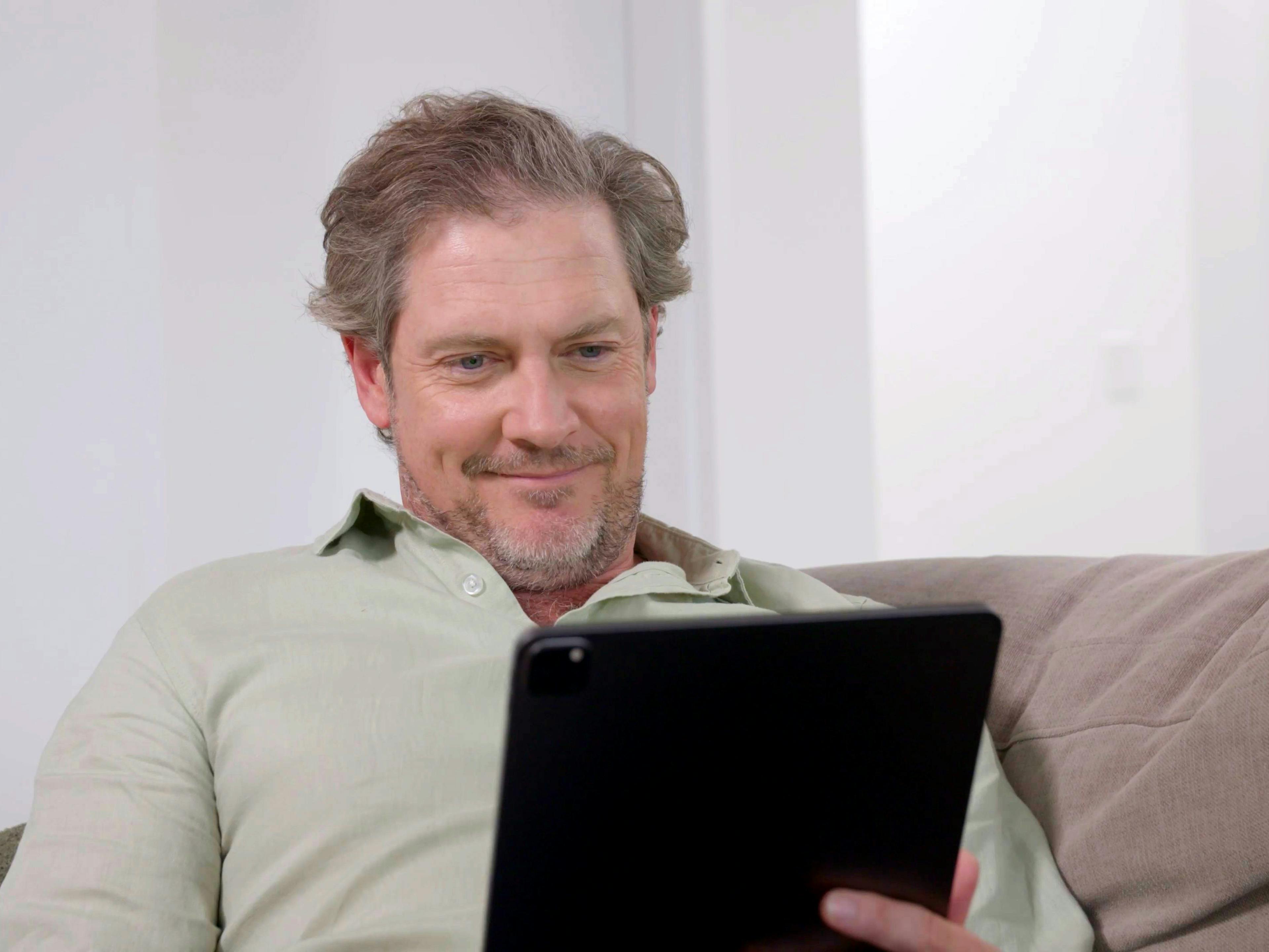 man booking a consult on ipad