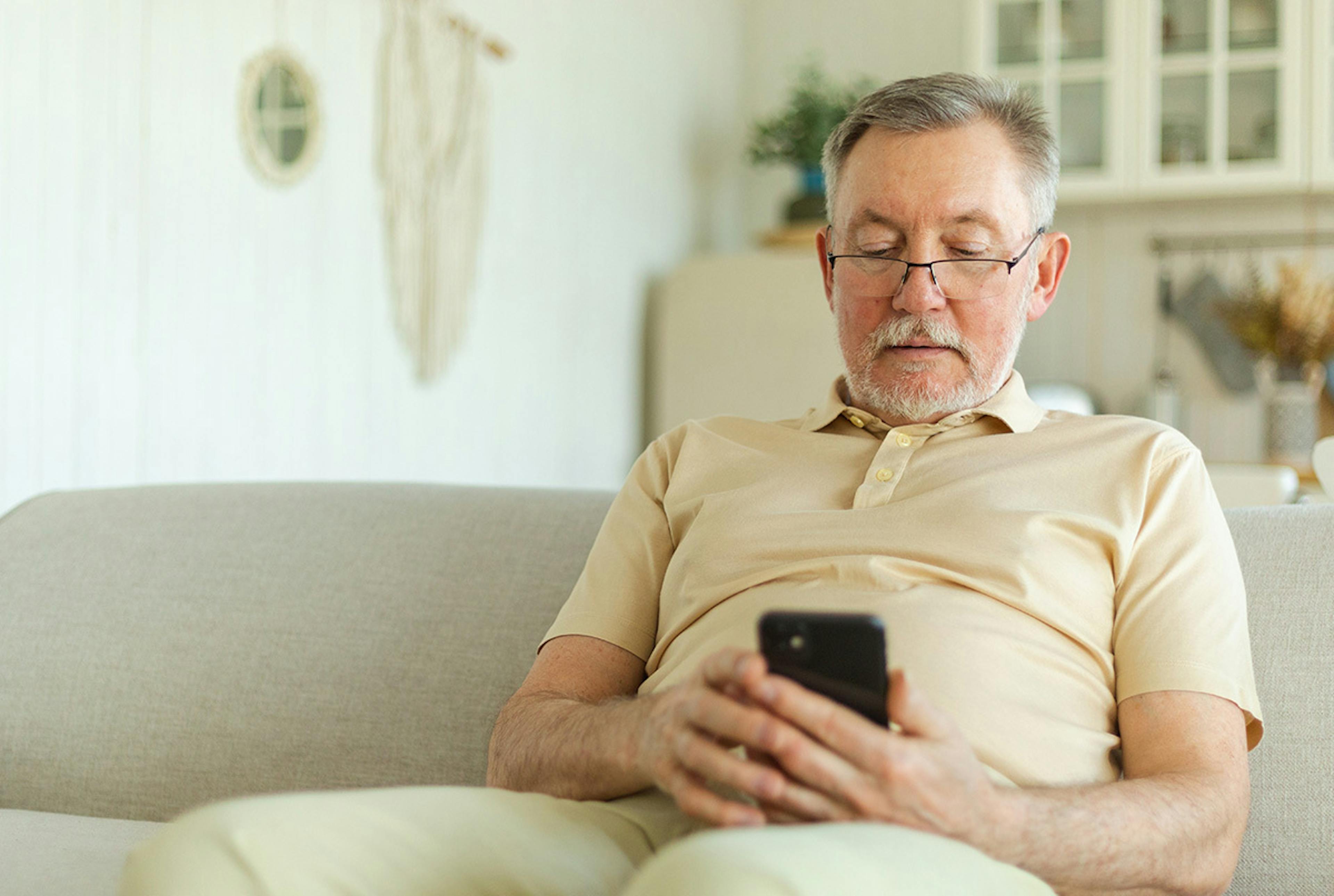 An older man looking at his phone 