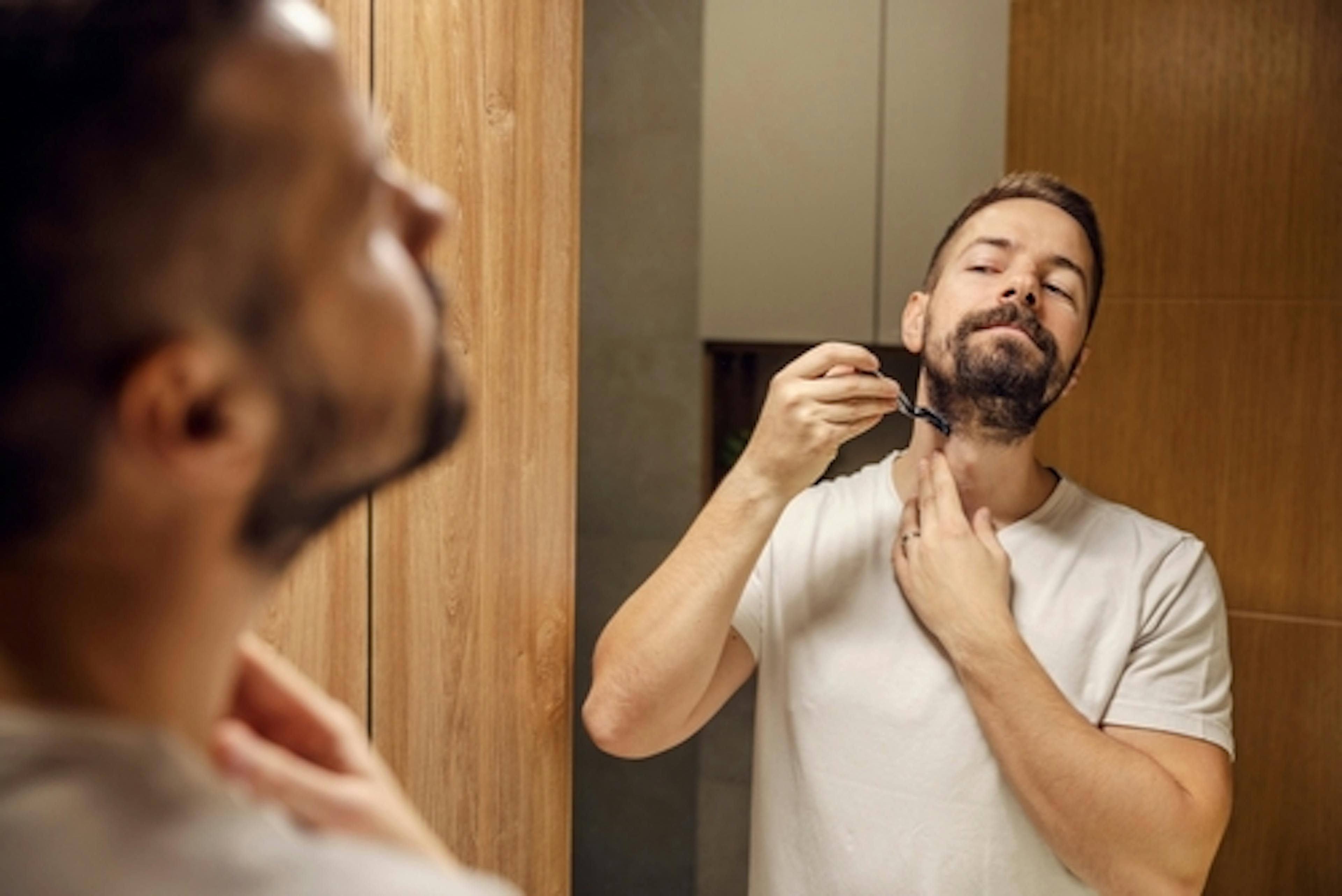 man shaving in front of a mirror