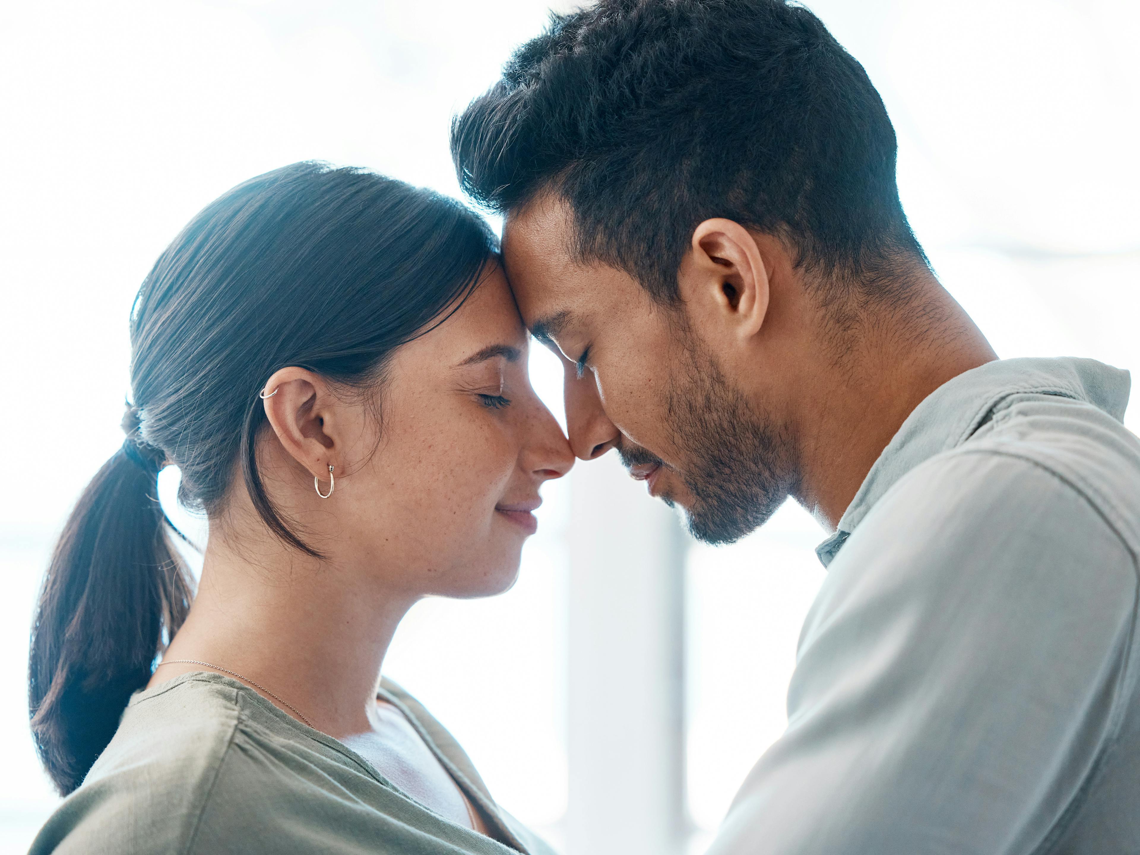 couple holding each other close with faces touching 