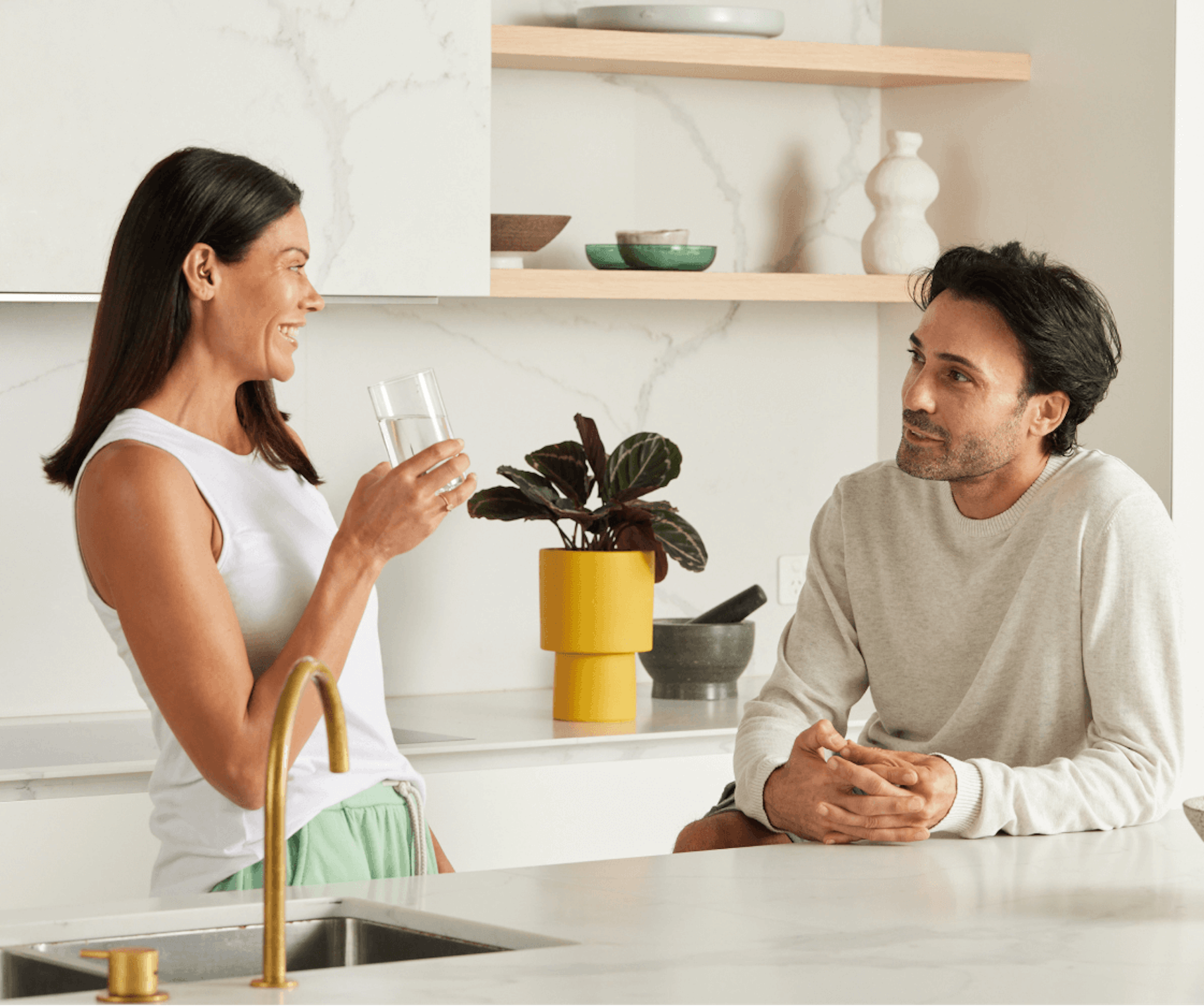 A man and woman having a friendly conversation in a kitchen.