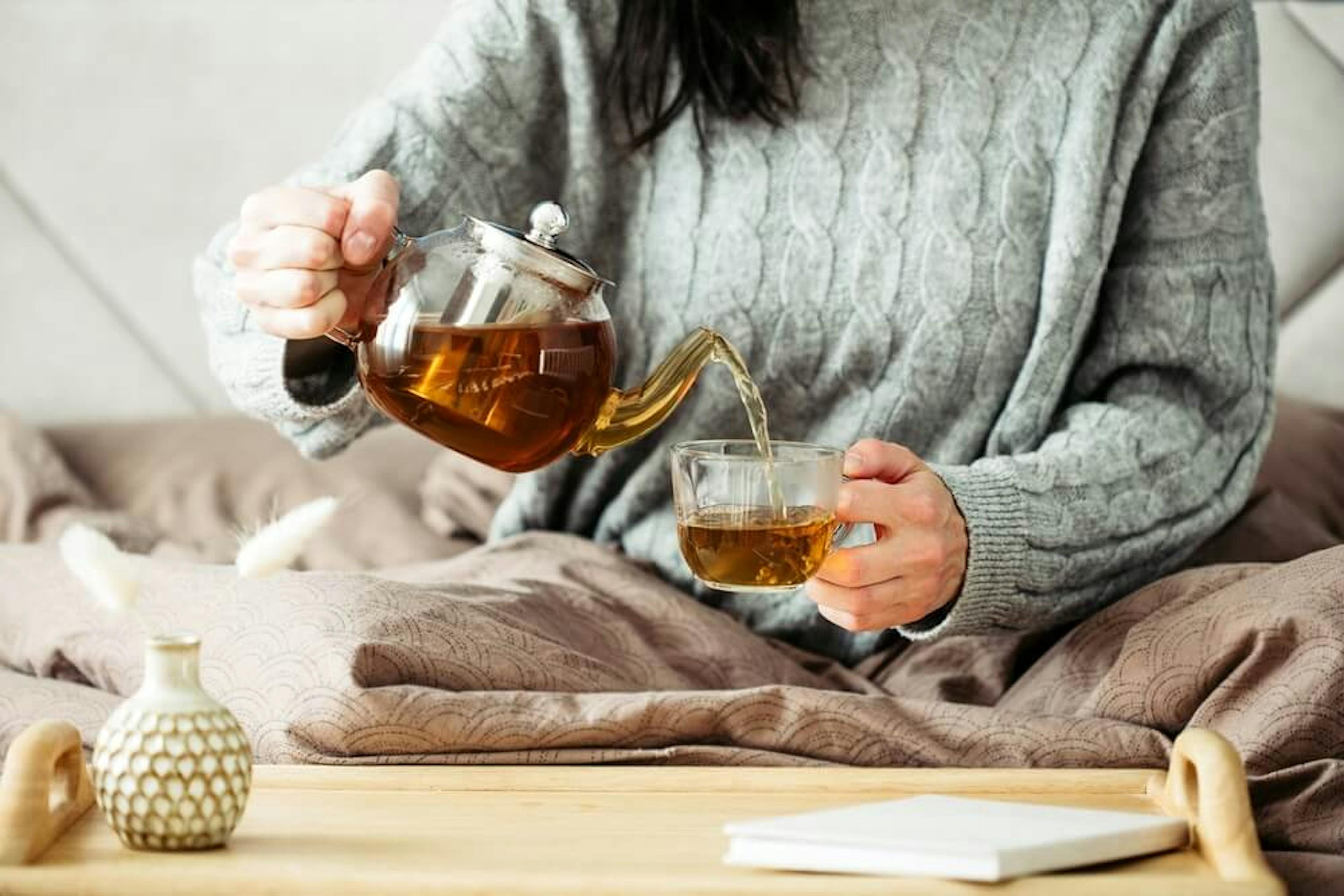 Woman poring green tea in a cup