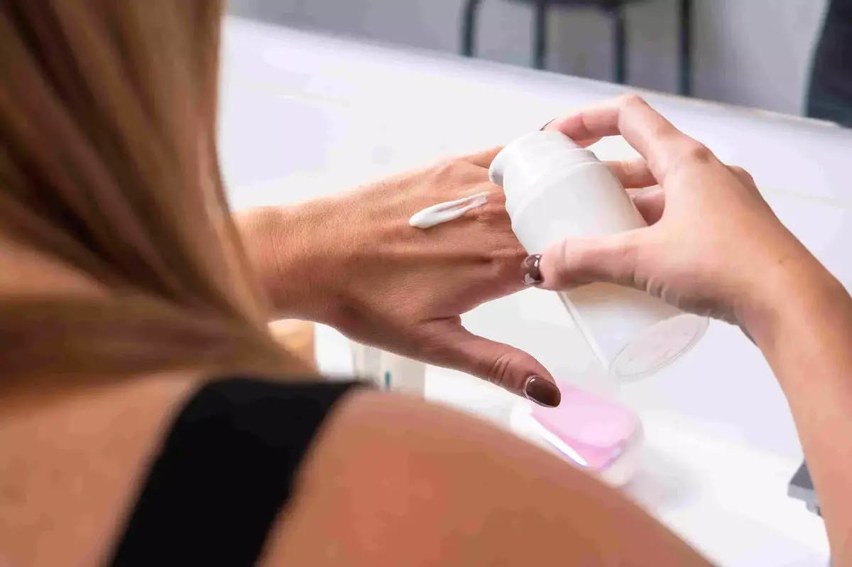 A woman testing retimoid cream on her hand