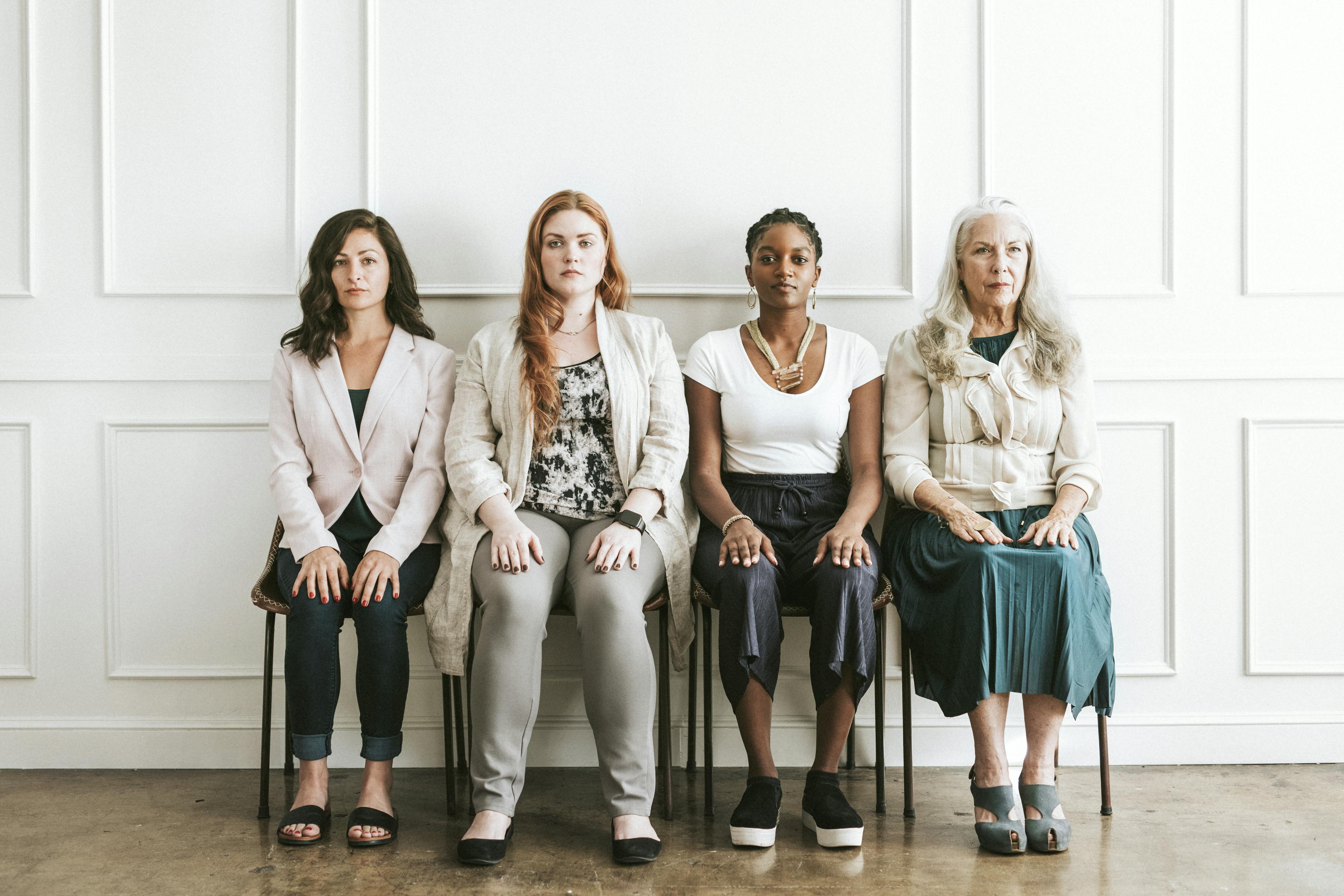 Four women sitting together, looking worried