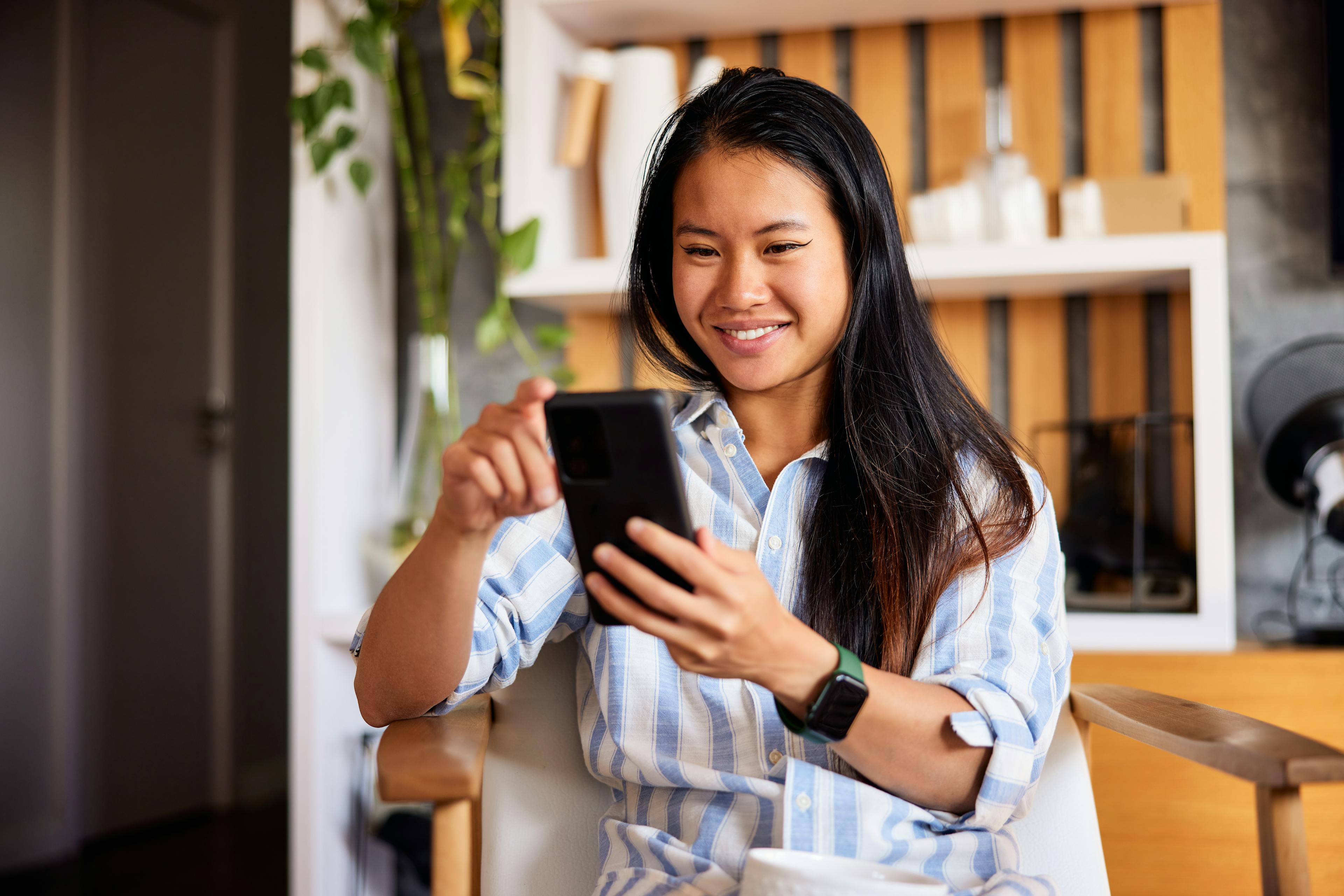 Lady smiling while using her phone