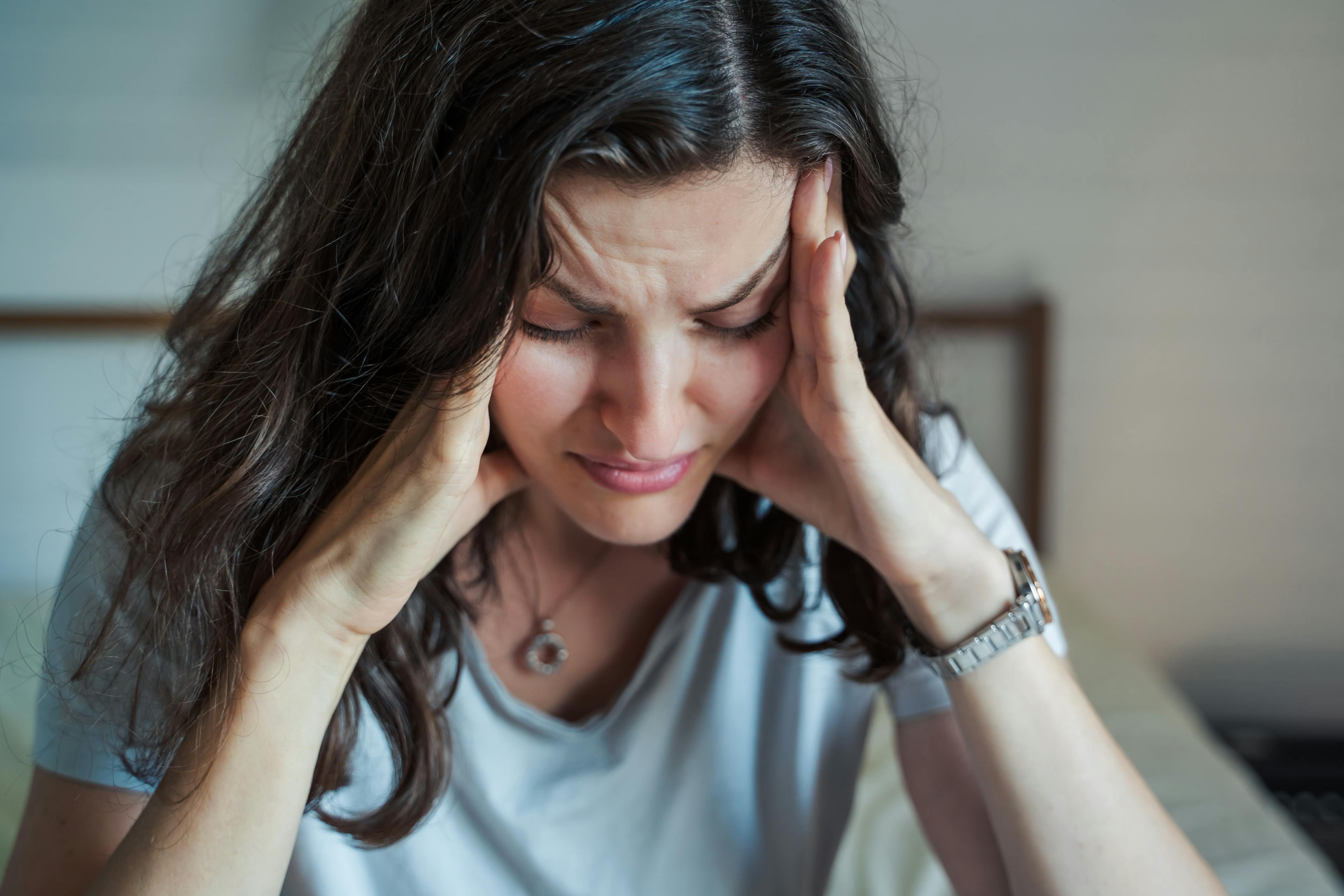 Woman looking stressed, holding her head