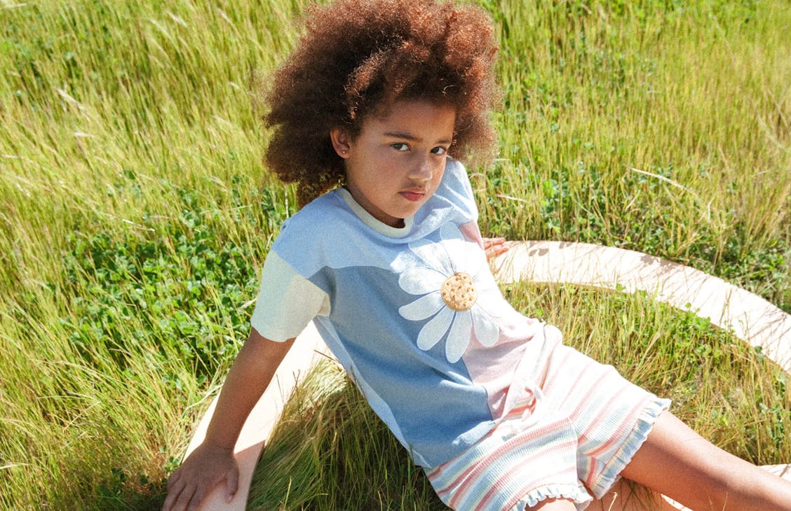 Young female model wearing the panel thrift tee in Blue-Pink-Yellow with the Charlie shorts in Eva Stripe. 