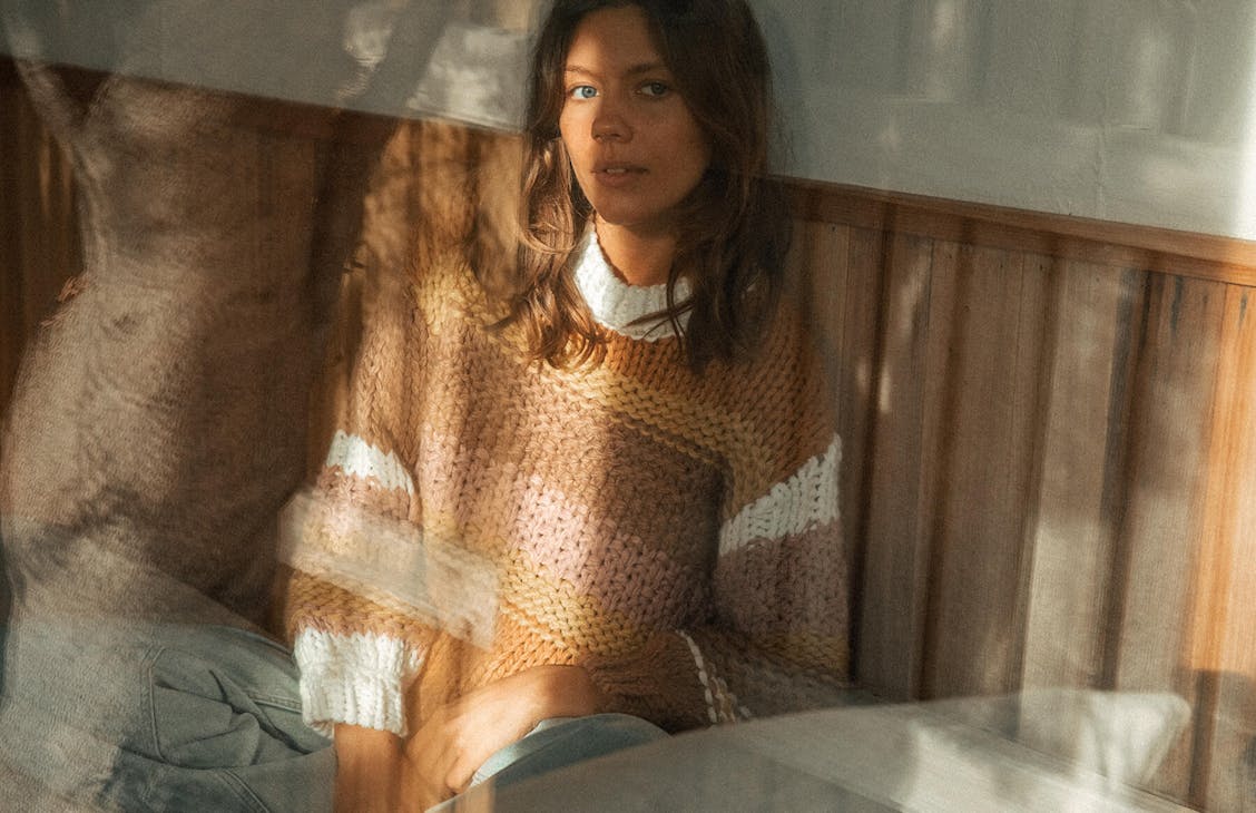 Female model wearing the haven knit in haven stripe. 