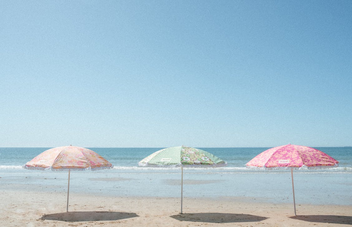 Image of three umbrellas in a row at the beach